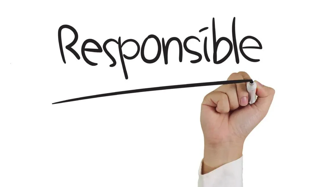 A hand holding a white dry-erase marker writes the word "Responsible" in black script on a white background. A long, straight line is drawn underneath the word.